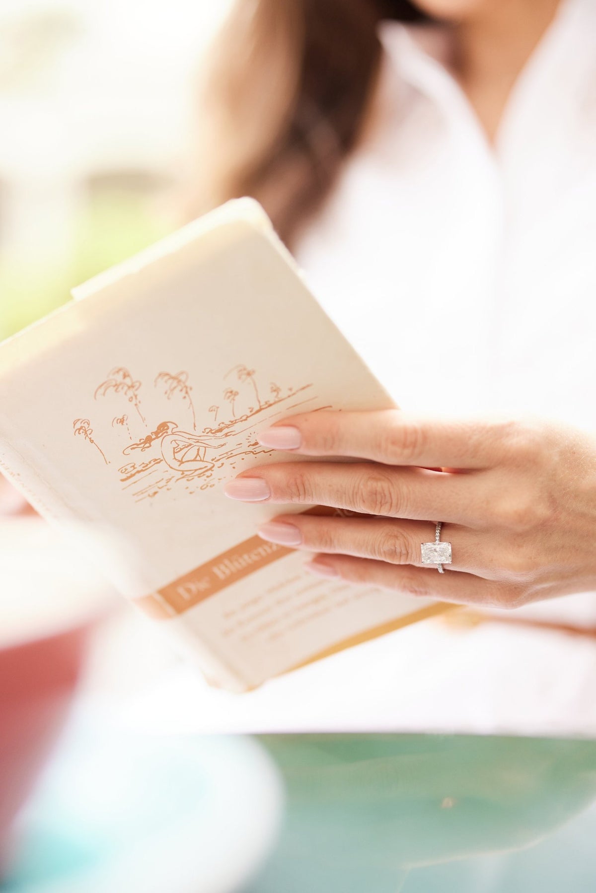 Verlobungsring mit Radiant Diamant auf einem Buch